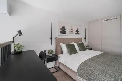 a bedroom with a bed and a table and a desk at Brand New Loft 61 in Pakopi
