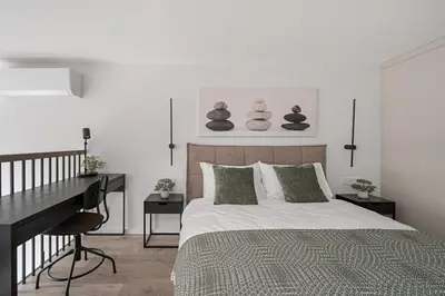 a bedroom with a bed and a desk and a piano at Brand New Loft 61 in Pakopi