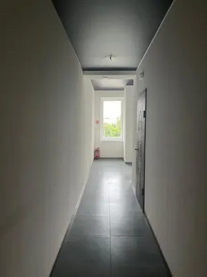 a hallway with a window in a white room at Apartamentai 2 in Raseiniai