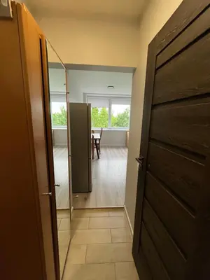 a hallway with a door and a room with a table at Apartamentai 2 in Raseiniai
