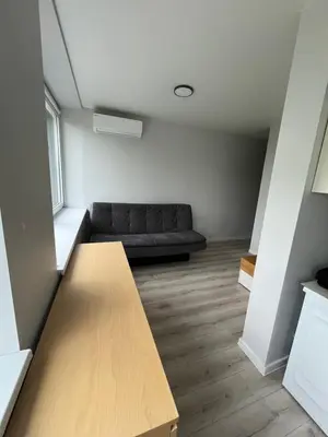 a living room with a couch and a wooden table at Apartamentai 2 in Raseiniai