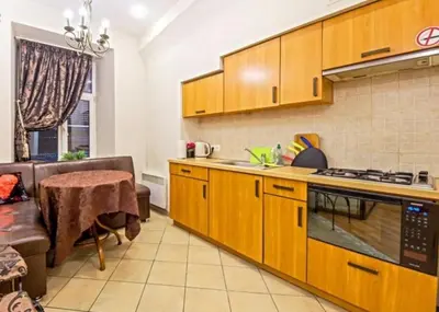 a kitchen with wooden cabinets and a table in a room at Best location Old Town Choise in Vilnius