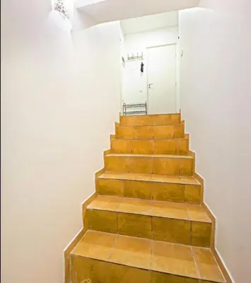 a stairway with wooden steps and a white door at Best location Old Town Choise in Vilnius