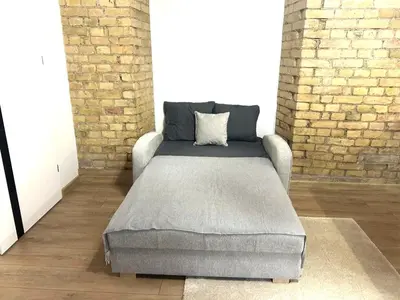 a bed in a room with a brick wall at Riverside Vilnius in Vilnius