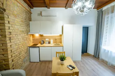 a kitchen with white cabinets and a brick wall at Riverside Vilnius in Vilnius