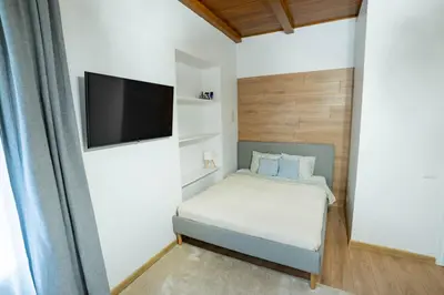 a small bedroom with a bed and a flat screen tv at Riverside Vilnius in Vilnius