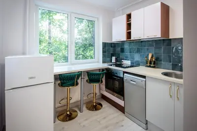 a kitchen with white cabinets and green bar stools at Urban escape Kaunas - One bedroom apartment Krėvės 16 in Kaunas