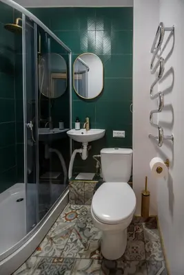 a green bathroom with a toilet and a sink at Urban escape Kaunas - One bedroom apartment Krėvės 16 in Kaunas