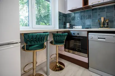 a kitchen with two green bar stools at Urban escape Kaunas - One bedroom apartment Krėvės 16 in Kaunas