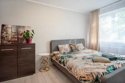 a bedroom with a bed and a dresser and a window at Urban escape Kaunas - One bedroom apartment Krėvės 16 in Kaunas