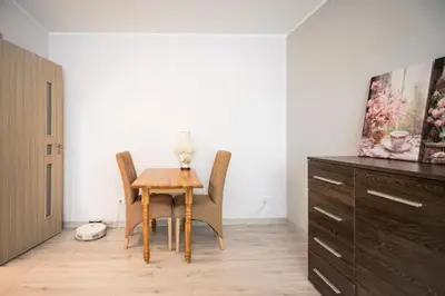 a dining room with a table and chairs and a dresser at Urban escape Kaunas - One bedroom apartment Krėvės 16 in Kaunas