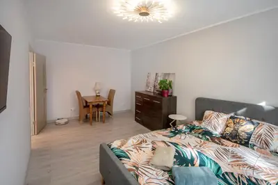 a living room with a bed and a table at Urban escape Kaunas - One bedroom apartment Krėvės 16 in Kaunas