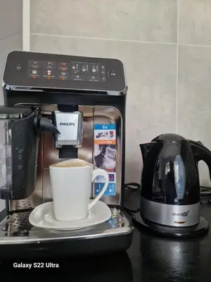 a coffee maker with a cup of coffee on a counter at RentA Citywalk Flat in Kaunas