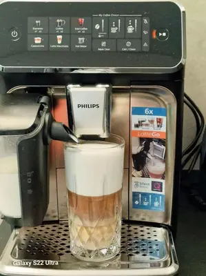 a coffee maker with a drink in a glass at RentA Citywalk Flat in Kaunas