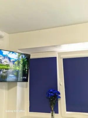 a flat screen tv on a wall next to a window at RentA Citywalk Flat in Kaunas