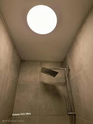 a bathroom with a shower with a skylight at RentA Citywalk Flat in Kaunas
