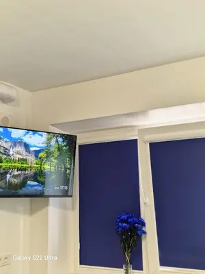 a flat screen tv on a wall next to a window at RentA Citywalk Flat in Kaunas