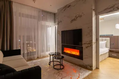 a living room with a fireplace and a couch at Aparthotel Nemunas in Druskininkai
