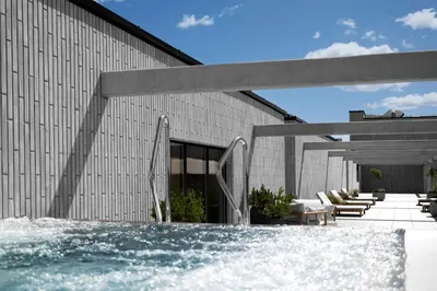 a swimming pool in front of a building at Aparthotel Nemunas in Druskininkai