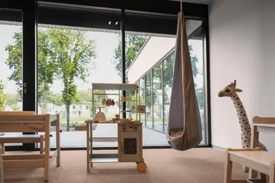 a room with a giraffe and a table and chairs at Aparthotel Nemunas in Druskininkai