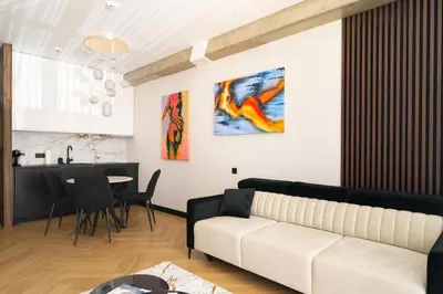 a living room with a white couch and a table at Aparthotel Nemunas in Druskininkai