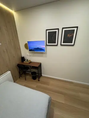 a bedroom with a bed and a desk with a television at 12 New Airport Apartment in Pakopi