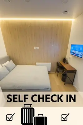 a room with a bed and a desk with a bed and a sign that says at 12 New Airport Apartment in Pakopi