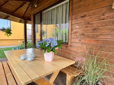 a wooden table with a vase of flowers on it at Apartamentai Jurbarko centre in Jurbarkas