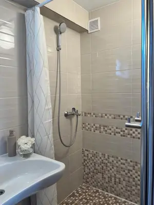 a bathroom with a shower and a sink at Apartamentai Jurbarko centre in Jurbarkas
