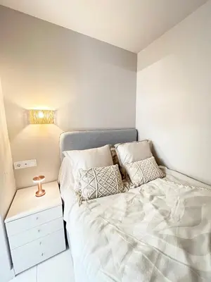 a small bedroom with a bed and a night stand at Charming City-Center Apt I ᴄohost in Vilnius
