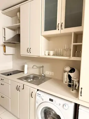 a white kitchen with a washing machine and a sink at Charming City-Center Apt I ᴄohost in Vilnius