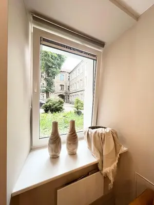 three white vases sitting on a window sill at Charming City-Center Apt I ᴄohost in Vilnius