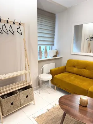 a living room with a yellow couch and a table at Charming City-Center Apt I ᴄohost in Vilnius