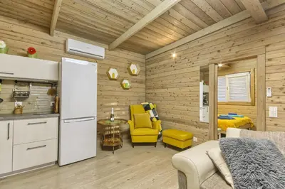 a kitchen with a refrigerator and a yellow chair in a room at Miško Kubilas in Randamonys