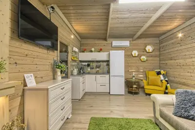 a kitchen with white cabinets and a yellow chair at Miško Kubilas in Randamonys