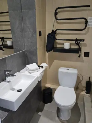 a bathroom with a white toilet and a sink at Private Hotel Room in the Corner of Vilnius City Centre in Vilnius