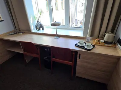 a wooden desk with two chairs and a window at Private Hotel Room in the Corner of Vilnius City Centre in Vilnius