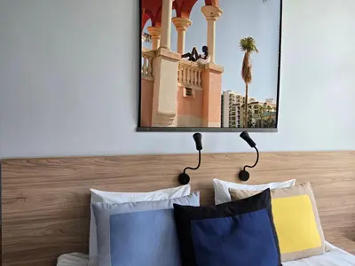 a mirror above a bed with two pillows at Private Hotel Room in the Corner of Vilnius City Centre in Vilnius