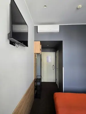 a room with a bed and a flat screen tv at Private Hotel Room in the Corner of Vilnius City Centre in Vilnius