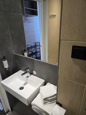 a bathroom with a white sink and a mirror at Private Hotel Room in the Corner of Vilnius City Centre in Vilnius