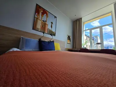 a bedroom with a large bed with a large window at Private Hotel Room in the Corner of Vilnius City Centre in Vilnius