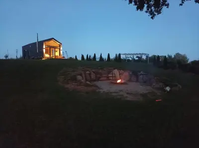 a fire pit in the middle of a field at night at Lake Garden Villa in Sadžiūnai