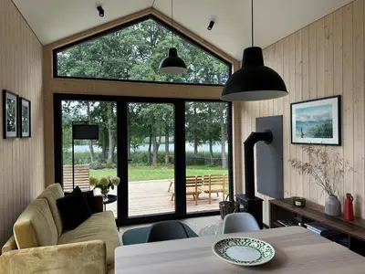 a living room with a couch and a table at Lake Garden Villa in Sadžiūnai