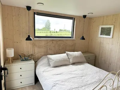 a bedroom with a white bed and a window at Lake Garden Villa in Sadžiūnai