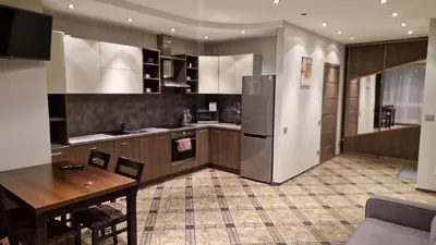 a large kitchen with a table and a refrigerator at Apartamentai Vilnius Lazdynėliai in Vilnius
