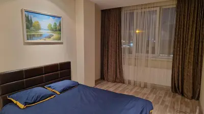 a bedroom with a bed with blue sheets and a window at Apartamentai Vilnius Lazdynėliai in Vilnius