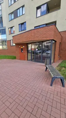 a bench sitting in front of a building at Apartamentai Vilnius Lazdynėliai in Vilnius