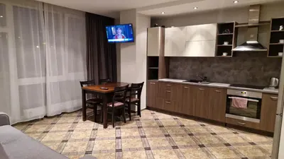 a kitchen with a table and a television in it at Apartamentai Vilnius Lazdynėliai in Vilnius