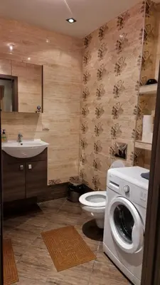 a bathroom with a washing machine and a toilet at Apartamentai Vilnius Lazdynėliai in Vilnius