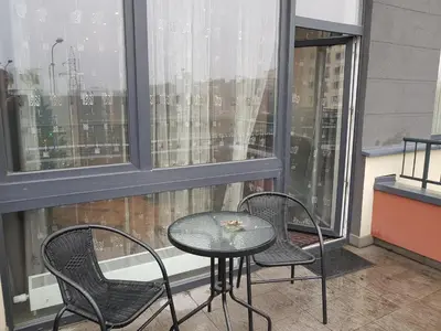 a table and chairs on a balcony with a window at Apartamentai Vilnius Lazdynėliai in Vilnius